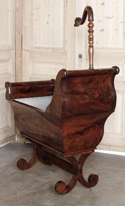 Fit for a royal infant! This stunning cradle has been kept in superlative condition for well over a century and a half! Hand-crafted from exotic imported mahogany with an exquisite grain pattern, it features sleigh-like lines that were popular