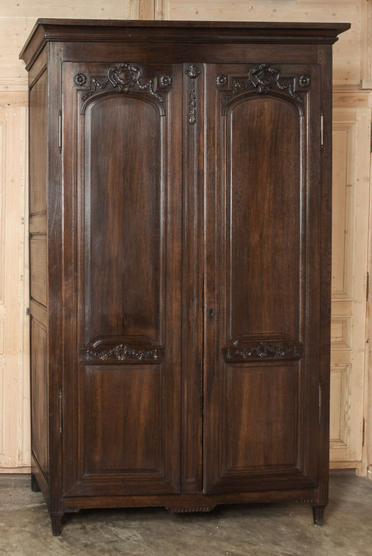 Hand-crafted by talented rural artisans, this stately armoire features hand-carved embellishment and copious storage space, with a presence that will command the room! Circa 1880s.<br />
Measures 104H x 64.5W x 23.5D