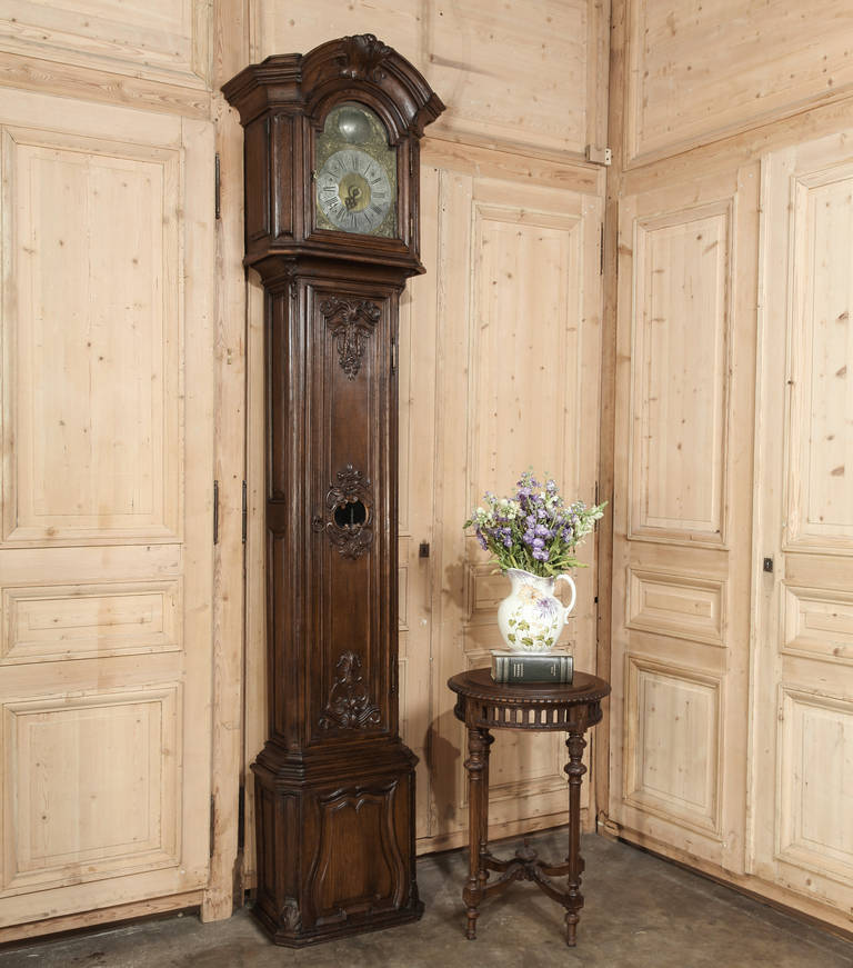 A stunningly well-preserved Morbier movement rests inside this impressive casework, handcrafted by master Liegoise cabinetmakers out of the preferred indigenous old-growth French white oak. A handsome arched crown centered with a crest is flanked by