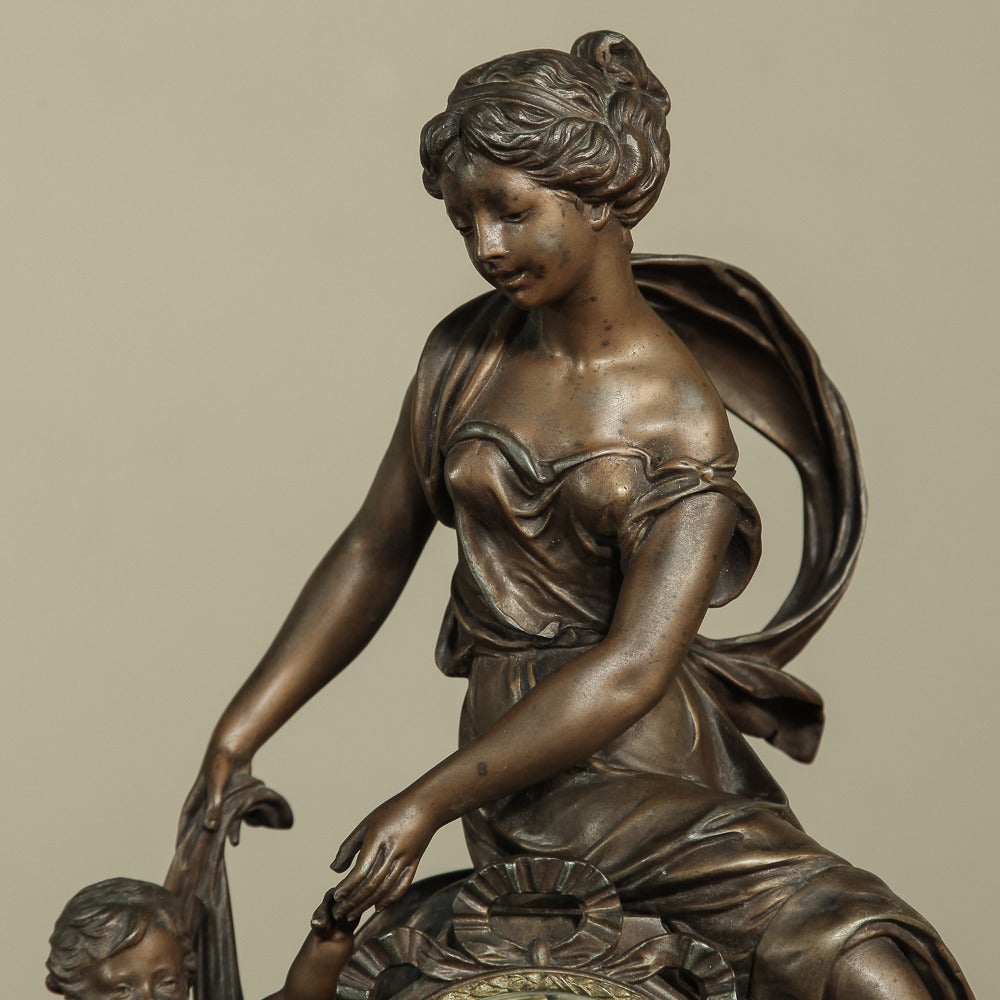 Eloquently expressing a mother's adoration for her child as only the Moreau family could, this stunning mantel clock was rendered in spelter then given a multi-hued patinated bronze finish for a stunning effect. Hand-painted enamelled dial is