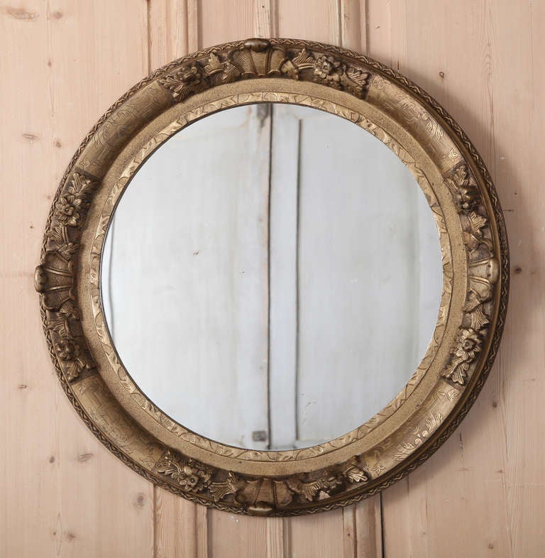 This round mirror remains in remarkable condition, and is reminiscent of porthole covers, being a popular design in the coastal cities of Europe. Ideal for the powder room or niche, it adds a certain Old World ambiance to any setting.
