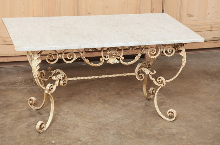 The amazing wrought iron base for this  Antique Wrought Iron Marble Top Coffee Table indicates the level of expertise attained by the metalsmith, with artistic scrolls rendered from red-hot iron!  Given a painted finish that has achieved a lovely