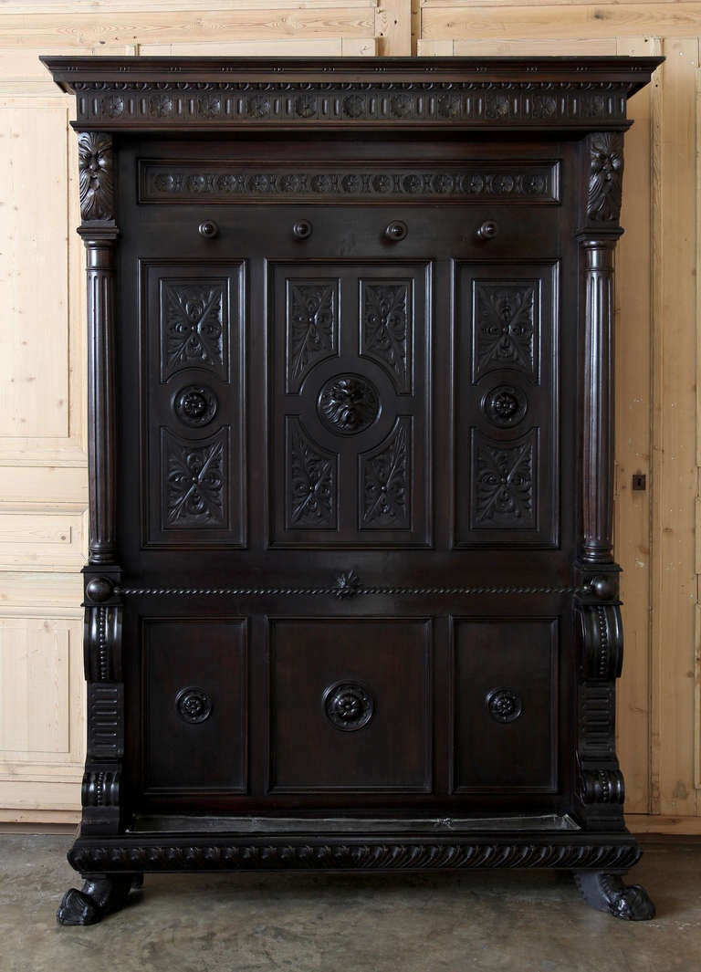 Hand-crafted from fine Italian walnut, this handsome hall tree features subtle Renaissance-inspired carvings including a lion's head on the center of the work, a symbol of kings! Elegant geometric designs and molding surround the entire affair,