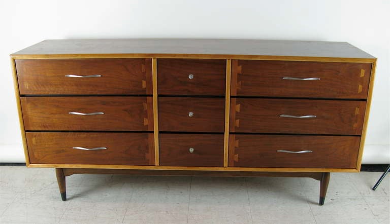 nice two toned wood with dovetail feature on front drawers. 3 smaller center drawers. Brushed metal handles. Beautiful piece,restored.