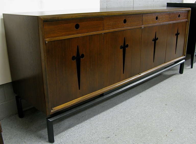 Warm walnut exterior. 4 pull out drawers on top w/ 4 doors on bottom with 3 figured maple drawers behind. This is part of Edmond Spence's Mexican series. Base and cutout handles are black lacquer.