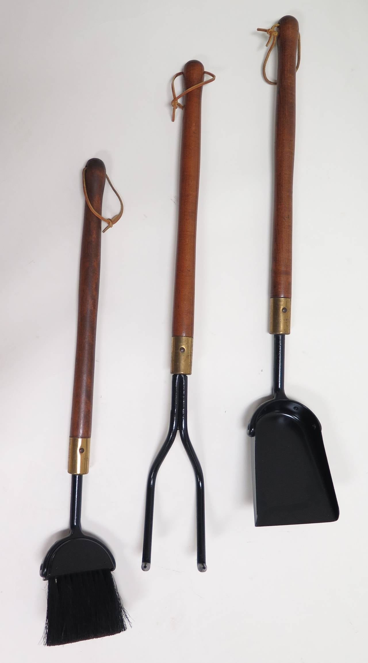 Dark walnut finish with brass sleeves. Solid wood handles. Iron tools and stand supports. New leather loops on the handles. Surfaces have been restored. Broom measures 28 in. high.