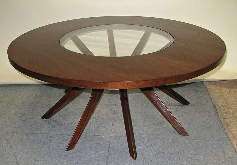 8 legs that attach around a soft gold tone aluminum center ring. The glass middle measures 21.5 inches diameter. Refinished. Nice table.