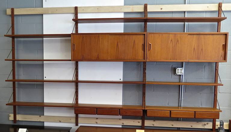 Sold by Raymor. Oil finish. Some minor scuffs, but overall nice vintage condition. All necessary hardware included. System includes five upright poles: 70 in. long, two cabinets: 39x 12x 14.75, 2 drawer units with three drawers: 39x 9.75x 4.75 and