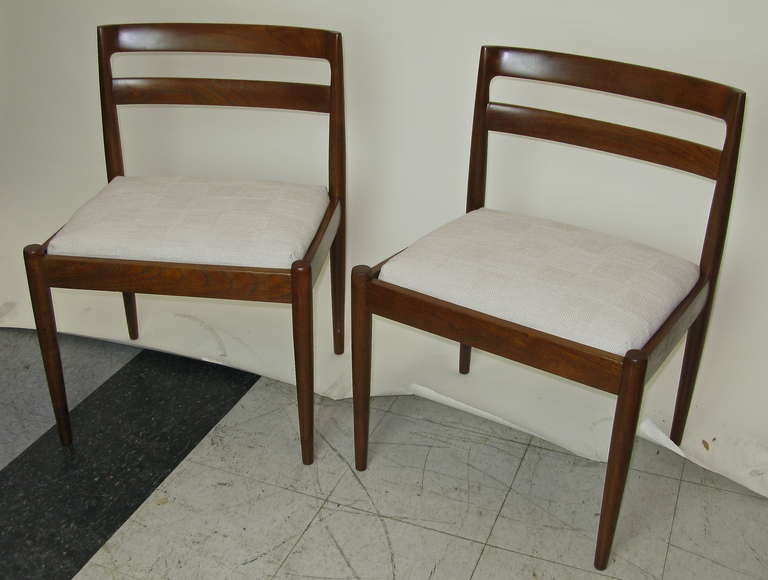 Teak wood. Warm brown finish. Reupholstered seats in linen/polyester blend fabric.