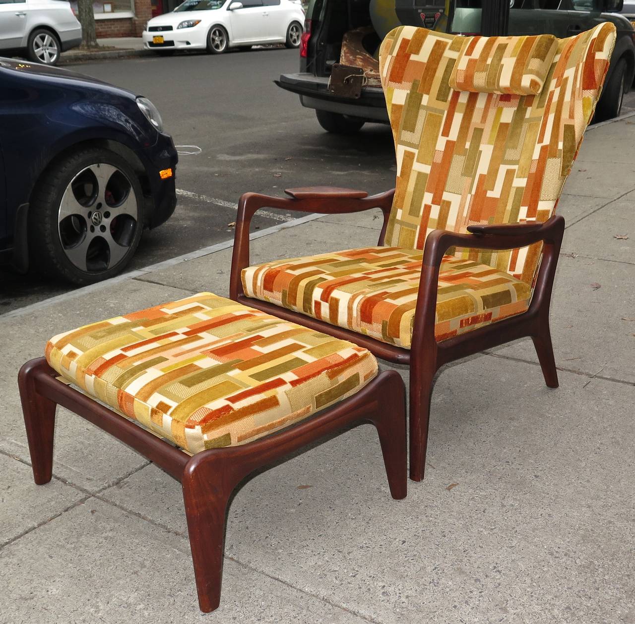Walnut construction. Good straps on both chair and ottoman. Fabric and foam in good condition and acceptable for use. Could be easily reupholstered with new fabric. Some minor scuffs on wood. Ottoman measures 25.5 in. W x 22 in. D x 14.5 in. H. 
