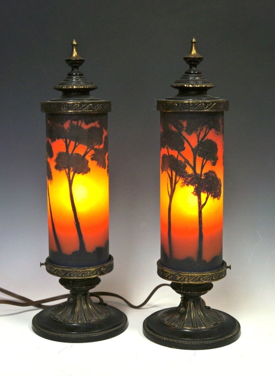 This is a pair of art deco Classique boudoir lamps with black enameled scenes against orange chipped ice type glass cylindrical shades. (the bulbs are too strong making them look more yellow than they are). They are mounted in decorated spelter