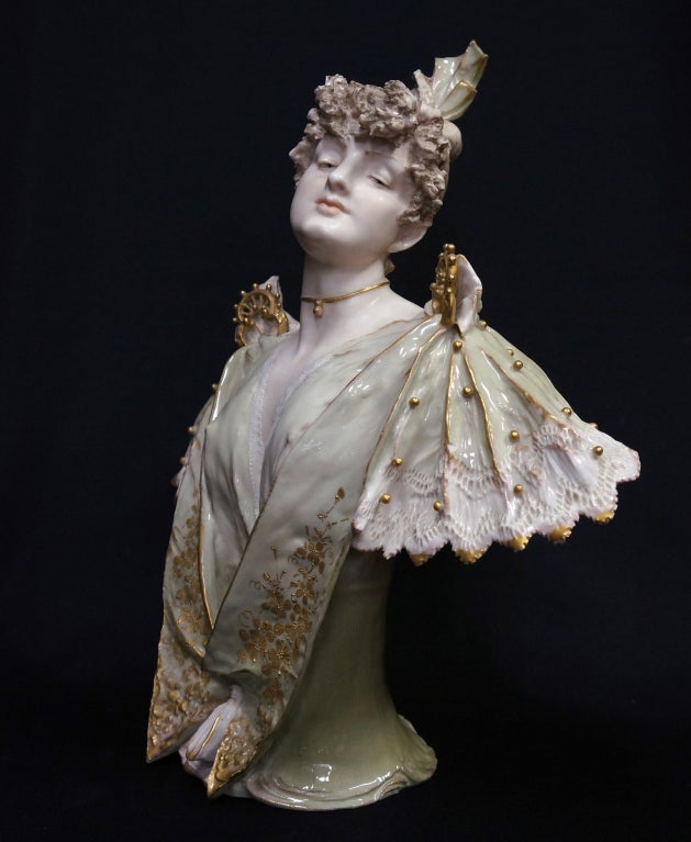 Art nouveau porcelain bust by Reissner, Stellmacher & Kessel depicting a lady dressed in lace and beaded frock. The high gloss glaze embellished with gilt flowers and beading contrasts with the satin finish of her skin. Signed with the RSK red mark