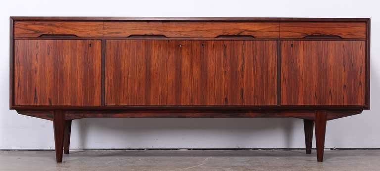 A gorgeous Moller style Danish Rosewood sideboard or credenza with exceptional wood grain.  Having 4 drawers and doors with shelving.