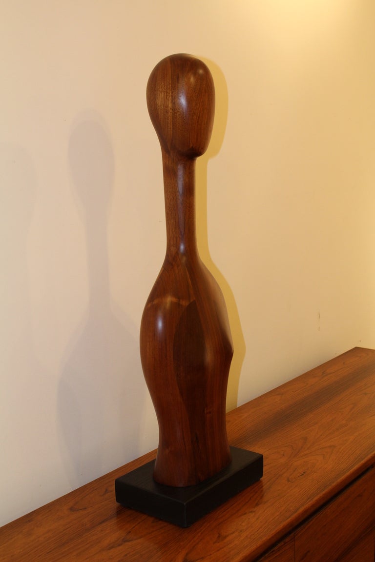 A modernist carved walnut figural sculpture of a woman signed Nancy Love 86. Her work was shown in Philadelphia galleries. Titled 