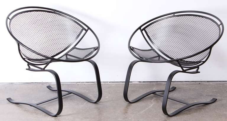 A pair of 1950's wrought iron Salterini cantilevered lounge chairs newly powder coated in black.