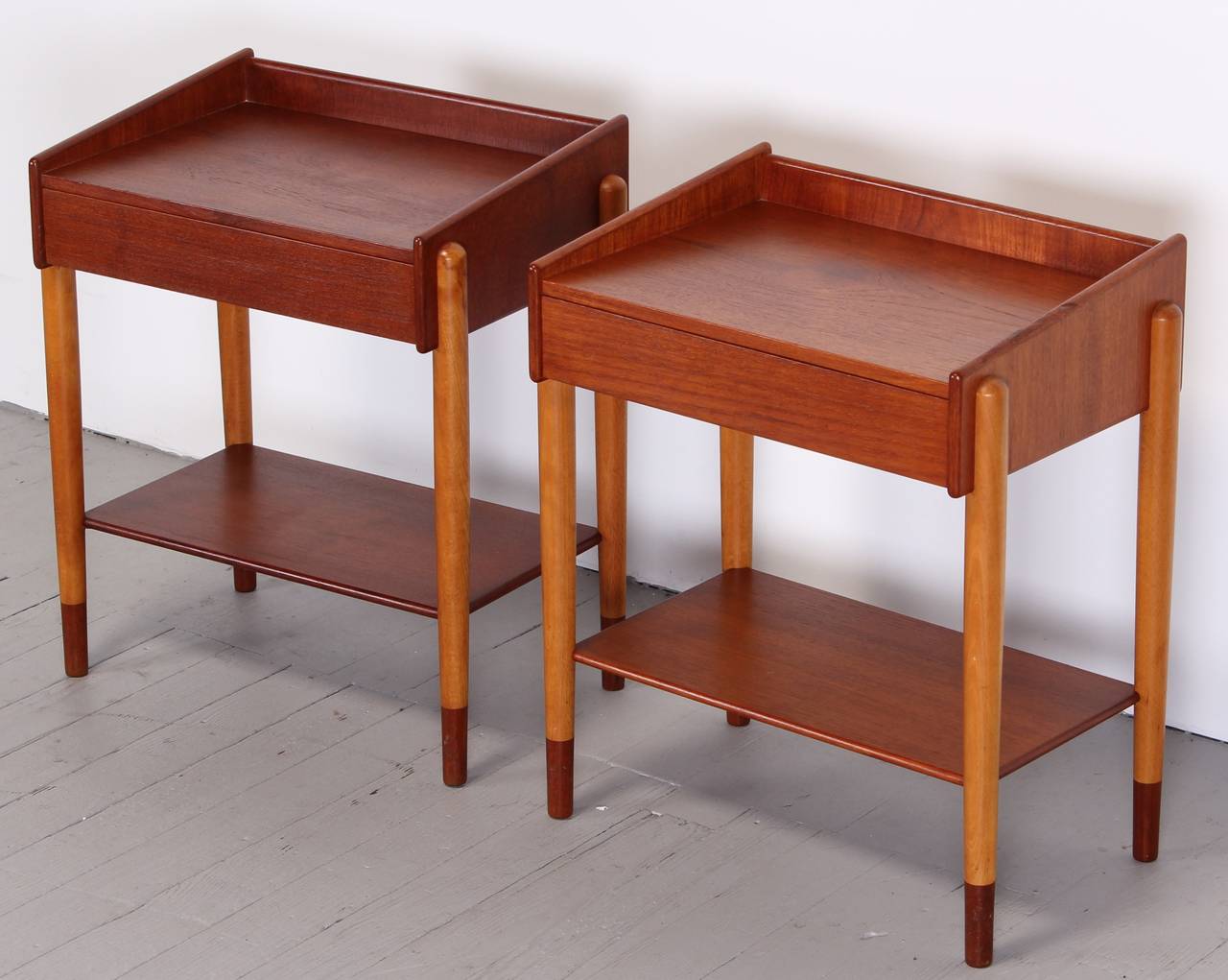 A pair of Borge Mogensen Danish side tables with one drawer. Tapered sides in teak wood with lower shelf. Tapered birch legs.