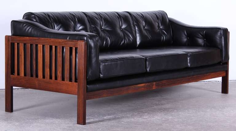 Luxurious Danish Mid Century Modern rosewood slatted sofa with beautiful grain and high quality black leather.
