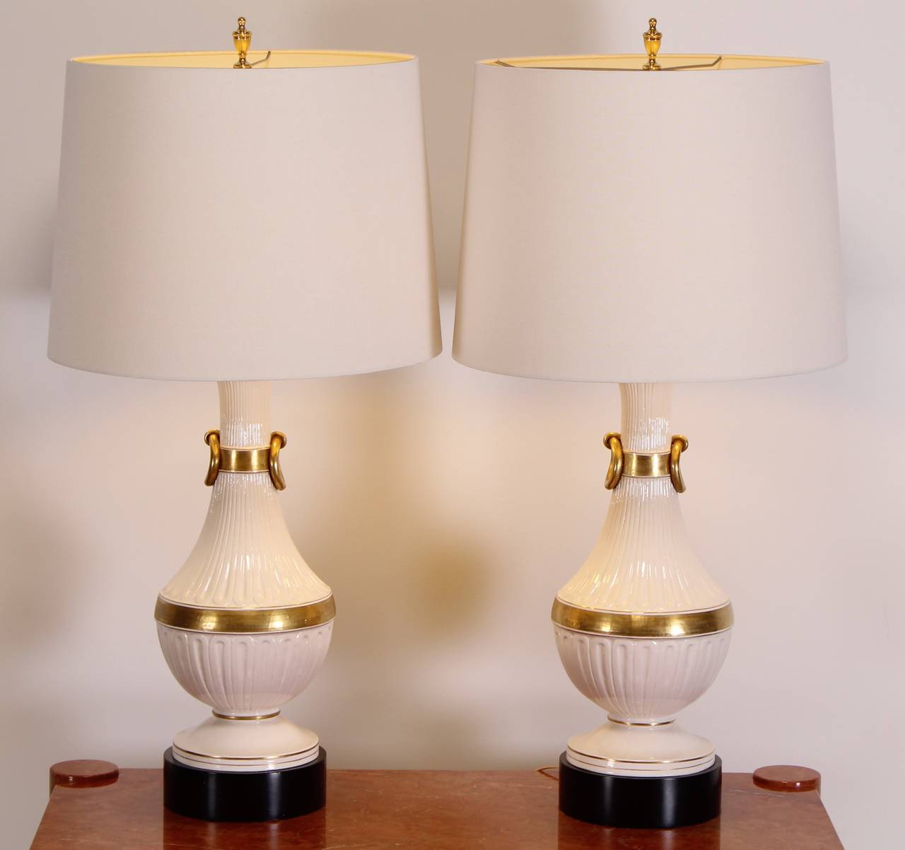A great pair of Hollywood Regency Classical Italian Pottery Lamps in the style of Chapman. White pottery with gold gilt Accents. Comes with linen shades if desired. Entire Height to top of finial is 44