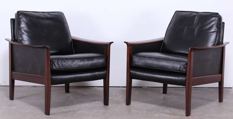 Luxurious Danish Mid Century Modern rosewood pair of chairs with beautiful grain and high quality black leather.