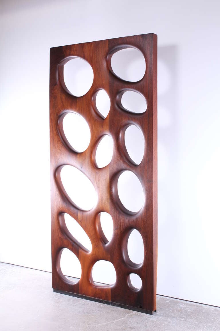 A wonderful carved and sculptural walnut 1950's abstract wall installation done in the style of Phillip Powell.  This beautiful piece is carved concave on one side and convex on the other side. Provenance: Purchased from the estate of Harry