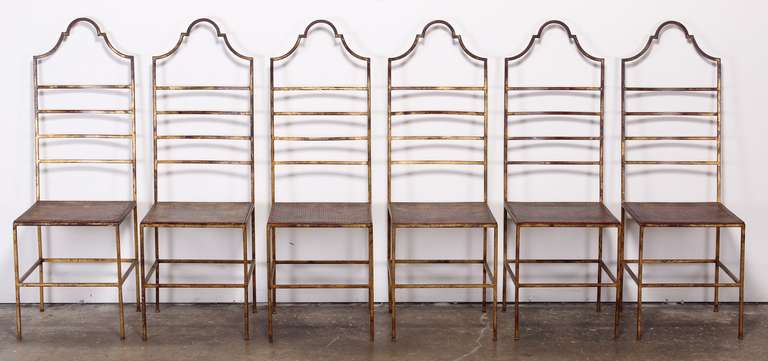 A set of six Italian wrought iron chairs with mesh seats. Painted in a distressed gilt Venetian red. 