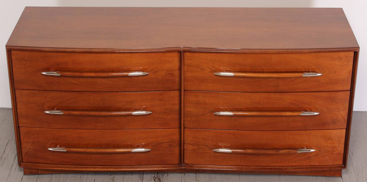 A walnut dresser or chest with six drawers and silver plate detail on pulls by T.H. Robsjohn-Gibbings. Terence Harold Robsjohn-Gibbings (1905–1976) was a British-born architect and furniture designer. Professionally refinished by Alternative