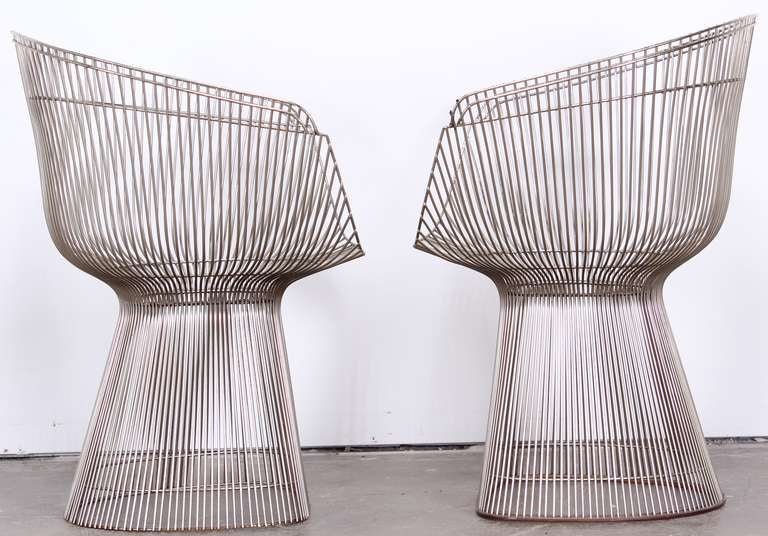 A pair of nickle plated dining chairs.