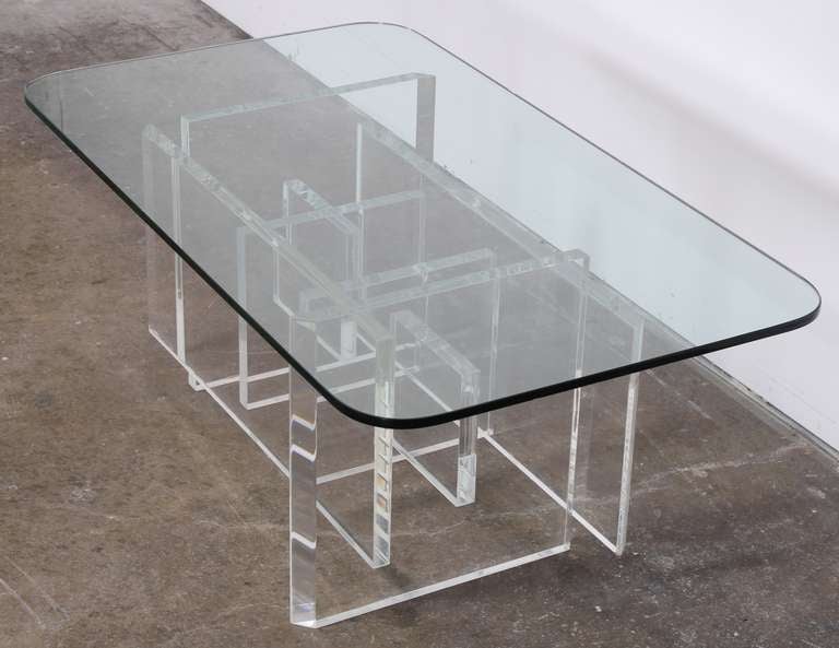A designer cocktail table with geometric Lucite base and glass top. New York City Delivery available for $249.00.