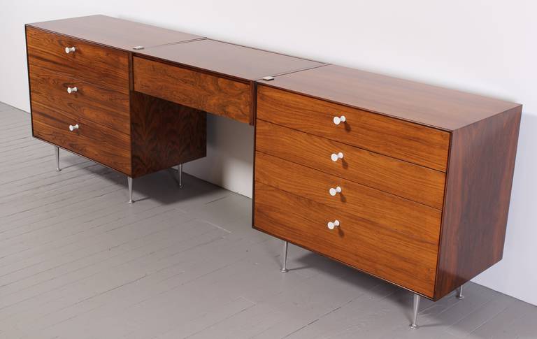 A three piece vanity with two chests that can be separated or configured as a vanity. This thin edge rosewood vanity has beautiful rich wood grain, original porcelain pulls and steel legs. The George Nelson vanity is in the original finish. New York