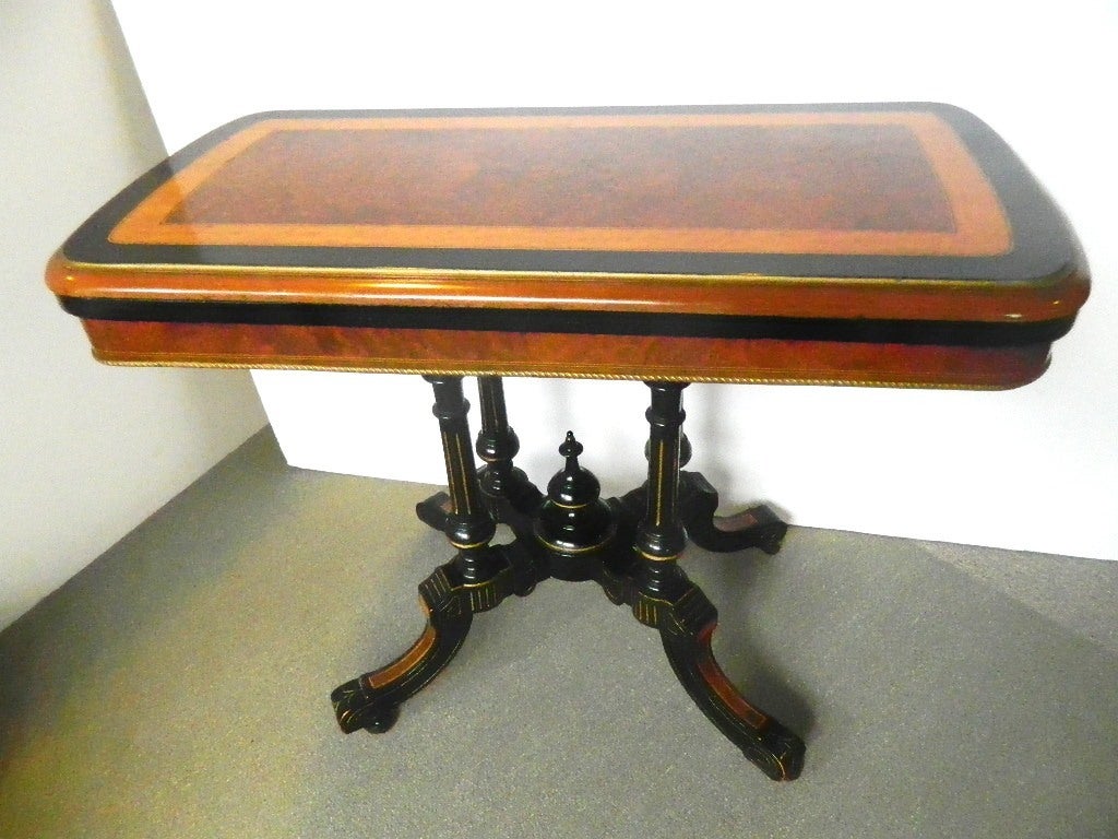 Handsome Victorian ebonized burled walnut card table. It swivels to open with a blue interior. Open it is 36