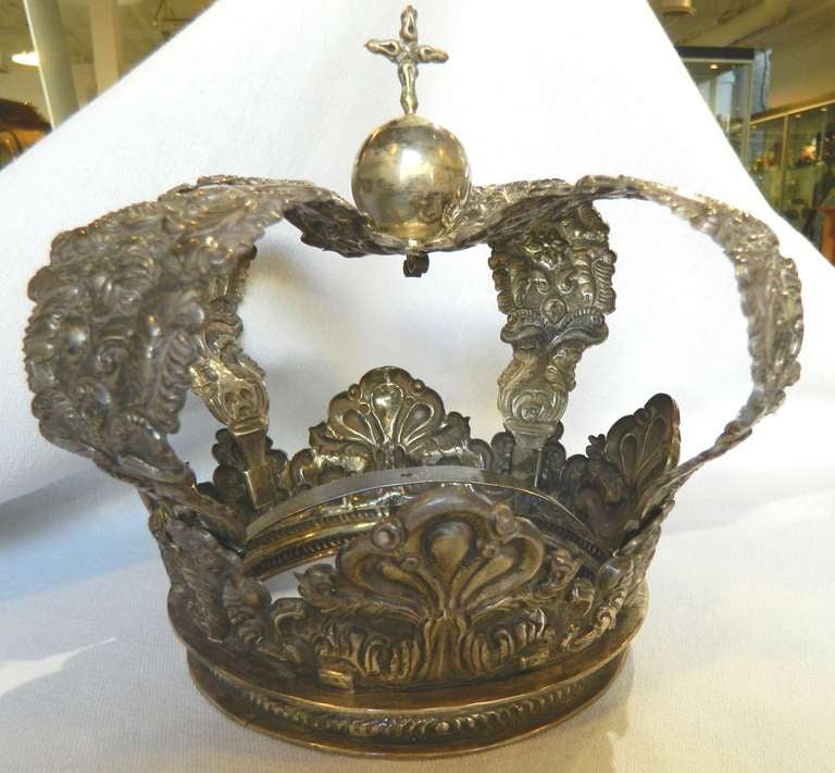 Large South American silver crown for a Santo or Madonna. It was made in sections with a removable top. This handmade crown has a repouseed surface with an orb and cross finial.