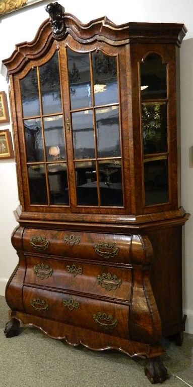 Small scale 18th century Bombay Dutch curio cabinet made of walnut with a burled veneer. Two glazed  doors over three drawers with paw feet.