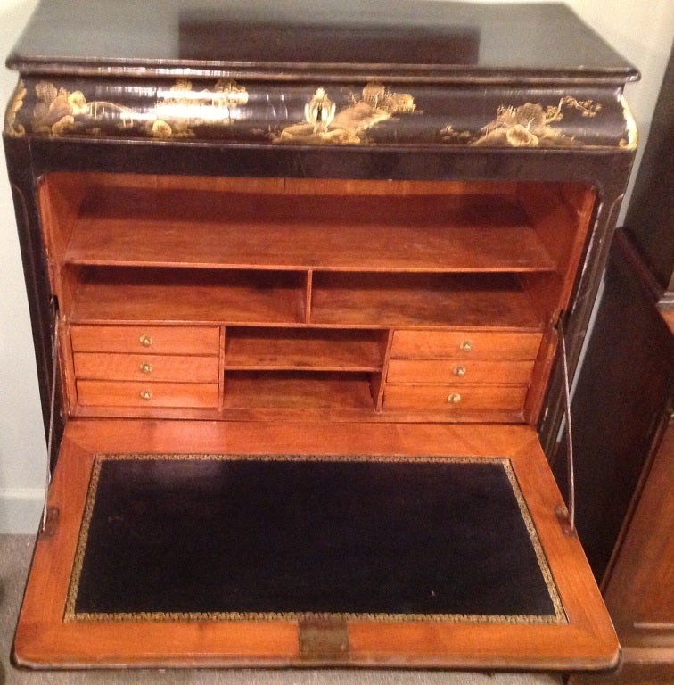 Antique gilt decorated black lacquer Chinoiserie drop front desk with one drawer over the fitted drop front with a two door one shelf cabinet below. The feet have bronze mounts. Original label to the underside- P.I.M. De Aix Bains Bercy Domicile