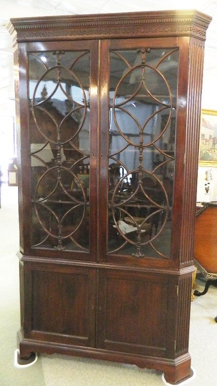 Georgian English mahogany corner cabinet with a molded cornice,2 glazed doors with old glass over a double blind door 2 shelf cabinet.
