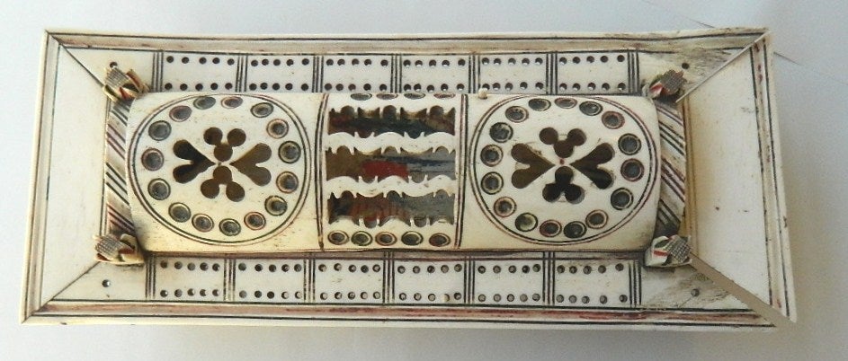 Napoleonic Prisoner of War Games Box carved of bone and painted. Combination domino and cribbage board with a rounded pierced hinged lid covering a sliding painted panel, set of 55'9'5.