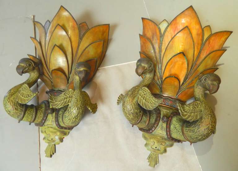 Pair of Art Deco bronze bird light fixtures from the Egyptian themed Majestic movie theatre in downtown Houston.  It opened in 1923 and was torn down in 1971.  They are patinated and polychromed bronze with stained glass shades.  Great original