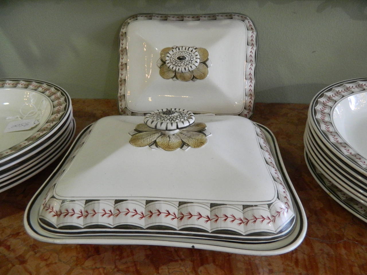 Partial dinner service of Wedgwood creamware in the lag and feather pattern
in sepia and red accents, circa 1800.
This group has 26 pieces including: 12 soup plates 9.5