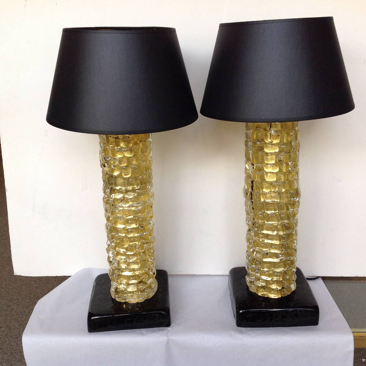 Pair of table lamps by Seguso with gold leaf encased in handmade glass on a connecting black glass base. Bases are 7