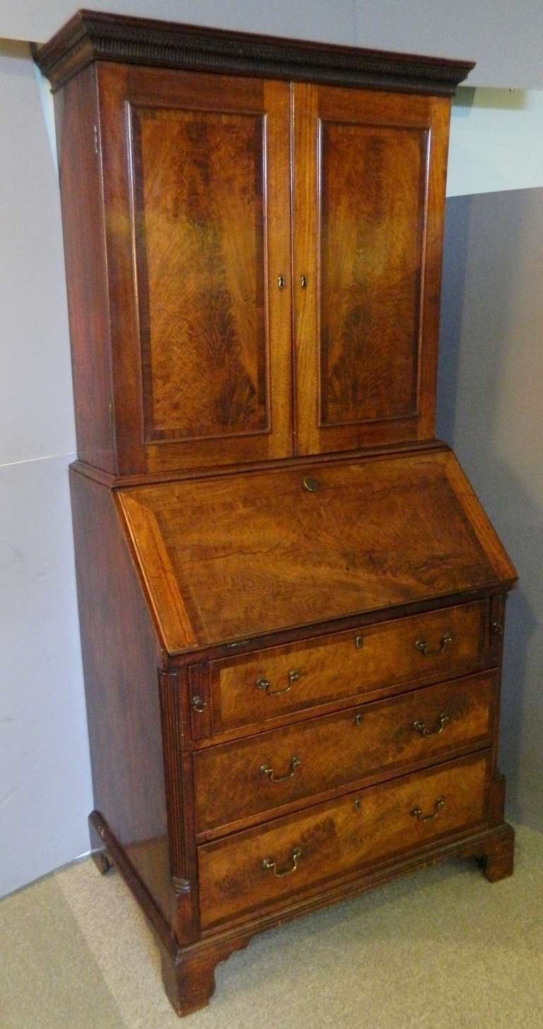 Antique English Georgian style mahogany secretary bookcase with cross banding to drawers and doors. Two doors enclosing a fitted interior over three large drawers. It has original pulls but has a replaced back on the base.
