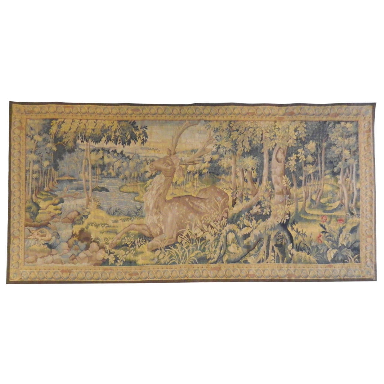Large antique Aubusson tapestry with a stag in the woods near a stream backed in taupe cotton with soft blues and taupe colors. It is 105" wide by 56.5" high. It has been professionally repaired.
France, circa 19th century.