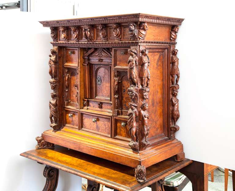 Early Italian walnut Bambooci cabinet dating 18th century or before. 
 Architecturally inspired with hidden drawers and cupboards with figural pulls. The carvings are of male and female figures, mothers holding children and bust pulls. Behind the