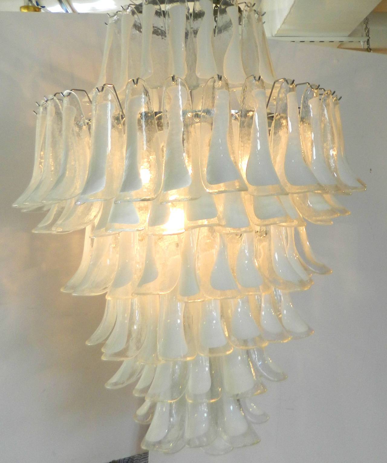 Large vintage Murano chandelier by Mazzega with handblown clear to white petal shaped glass pendants. There are eight tiers of petals and nine lights on a chromed metal frame. Unusual large size 48