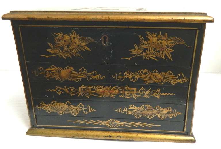 A great Mah Jongg set in a chinoiiserie decorated case from the early 20th century.  The original five tray box is black and gilt.  The games pieces are made of bone and bamboo with carved colored symbols.  There is an instruction book and a lock