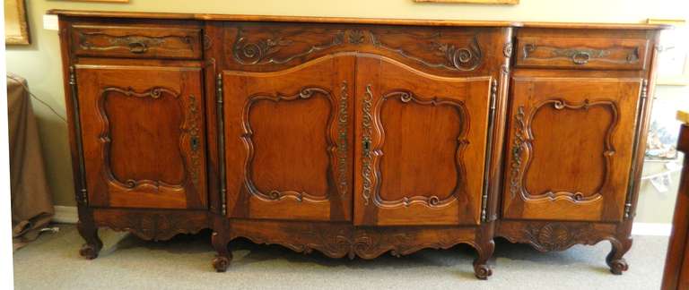Large 18th century French fruitwood buffet measuring 94" long and only 22" deep.  It has hand forged hardware and breadboard ends on the top. It has two drawers over four doors and there is one shelf in each cabinet.   Great old surface in