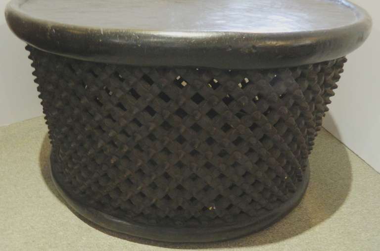 An African drum coffee table with carved wood lattice work on the sides.
Great flat top is perfect for a table.