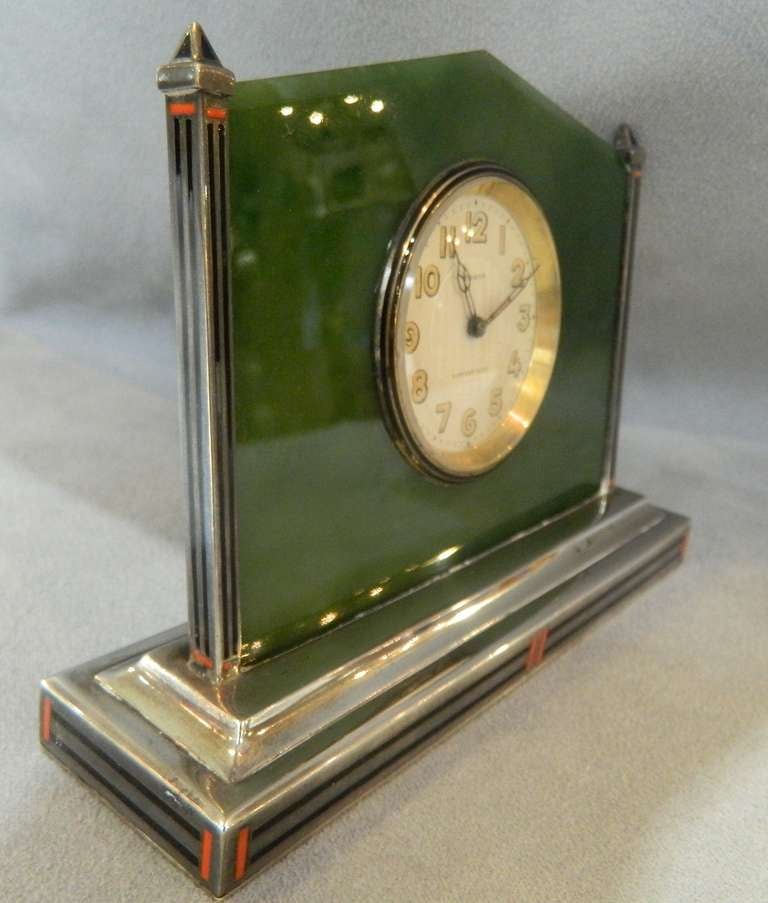 Tiffany clock with dark green jade in an enameled sterling frame and base. The face is marked 8 Days, TIFFANY & CO SWISS. It is in good condition.