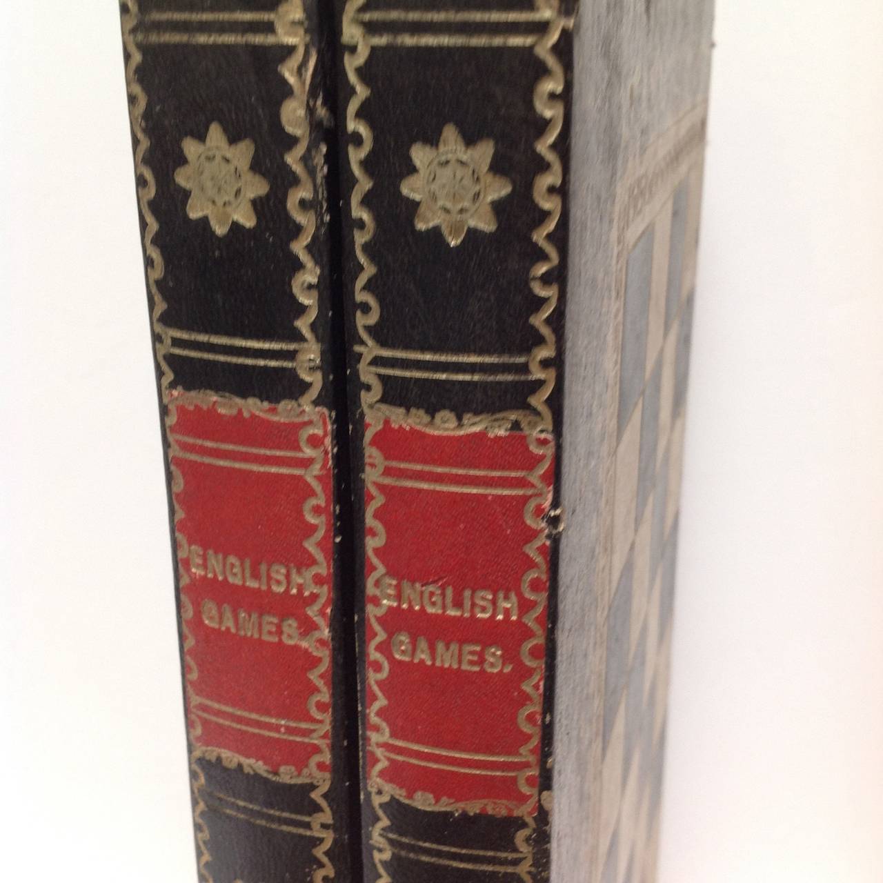 Leather and paper covered folding game board/box with chess and checkers on the outside and backgammon inside with a great overall book design. The spine reads English games Vol 1 Vol 2, early 20th century.