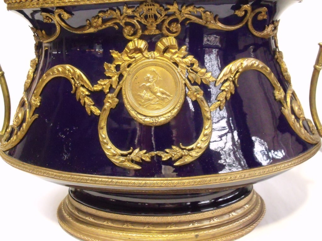 Cobalt blue Sevres type ceramic oval jardeinaire with gilt brass mounts,cherub decoration and bird handles. Brass medallion stamped by sculptor J P Le Gastelois.