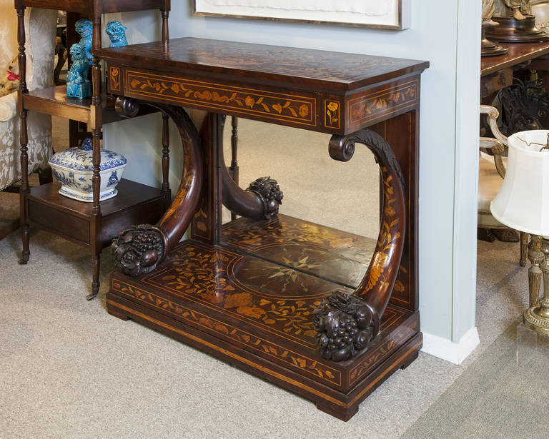 Dutch floral marquetry inlaid and carved one drawer mahogany pier table with cornucopia shaped columns.  The top has a marquetry basket of flowers as in photo 5. The base has a half compass that forms a whole as it reflects in the mirror as in photo