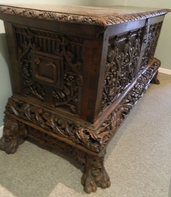 Antique Gothic style hand carved cassone lift top coffer with 3 dimensional depth to the elaborate designs. It has the original lock and key. Overall carved berries, leaves, acorns, thistles, lizard like creatures on the skirt and arches galore. The